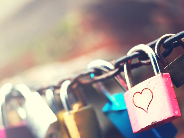 A set of padlocks locked in place on a big chain